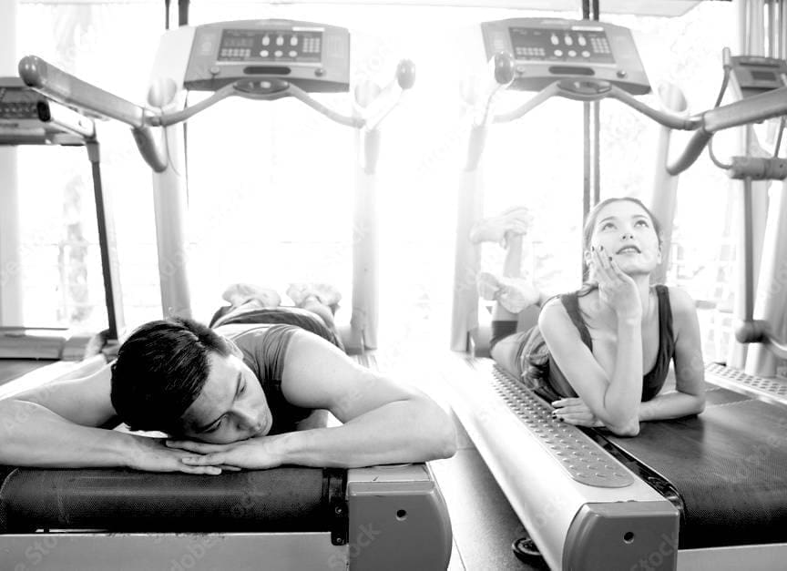 A couple relaxing on treadmills at the gym, highlighting the positive impact of exercise on mental health and stress reduction.